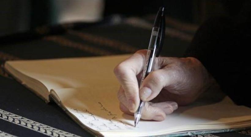 Image of a person hand writing in a notebook