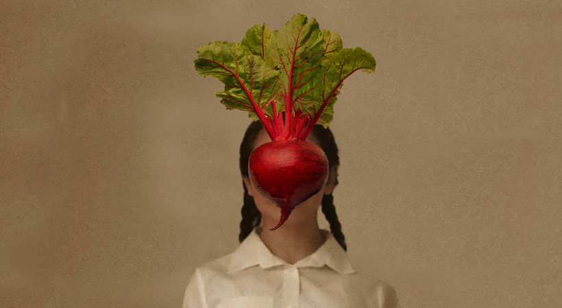 Girl with beetroot in front of her face