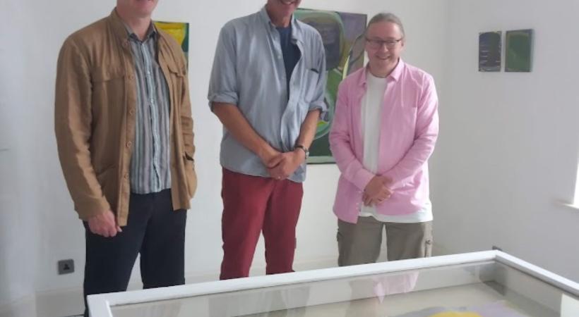 three artists standing beside a table