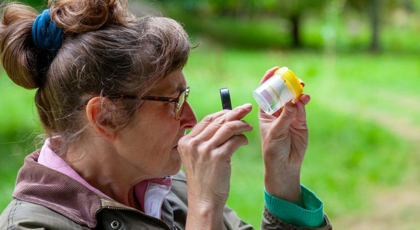 Lady looking at specimen in a small jar